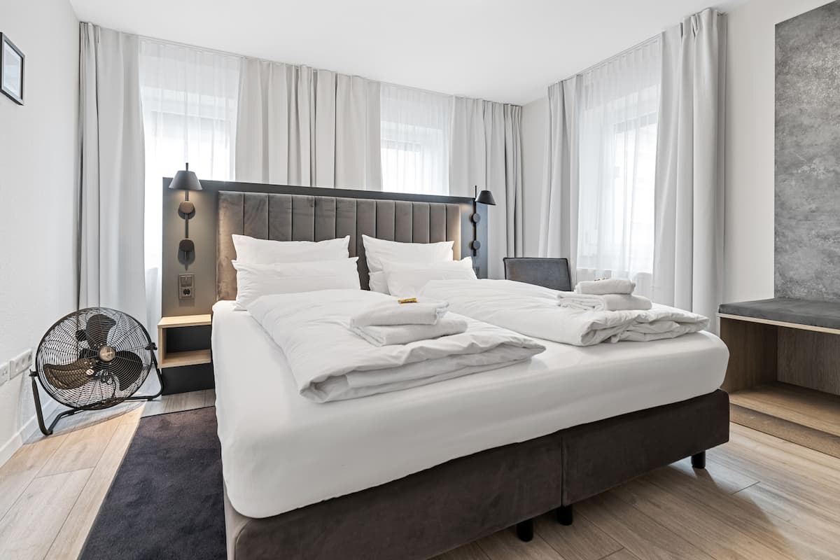 Een moderne hotelkamer met een groot bed, een bureau en een stoel.