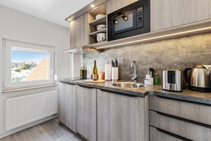 Apartamento Confort | Cocina privada | Frigorífico, microondas, horno y placa de cocina