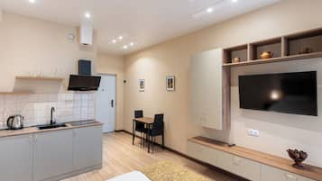 Una cocina moderna con comedor, televisor de pantalla plana y horno empotrado.