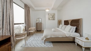 A bedroom with a bed, bedside tables, a desk, a chair, and a window with curtains. - 2BR apartment 2 minutes to beach Amwaj 4 (Dubai)