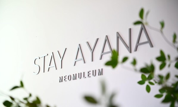 Un letrero con el texto 'STAY AYANA' y 'MÉO MULEUM'.