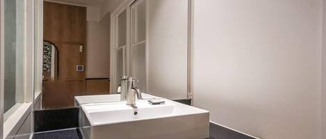 A bathroom with a white sink and a mirror.