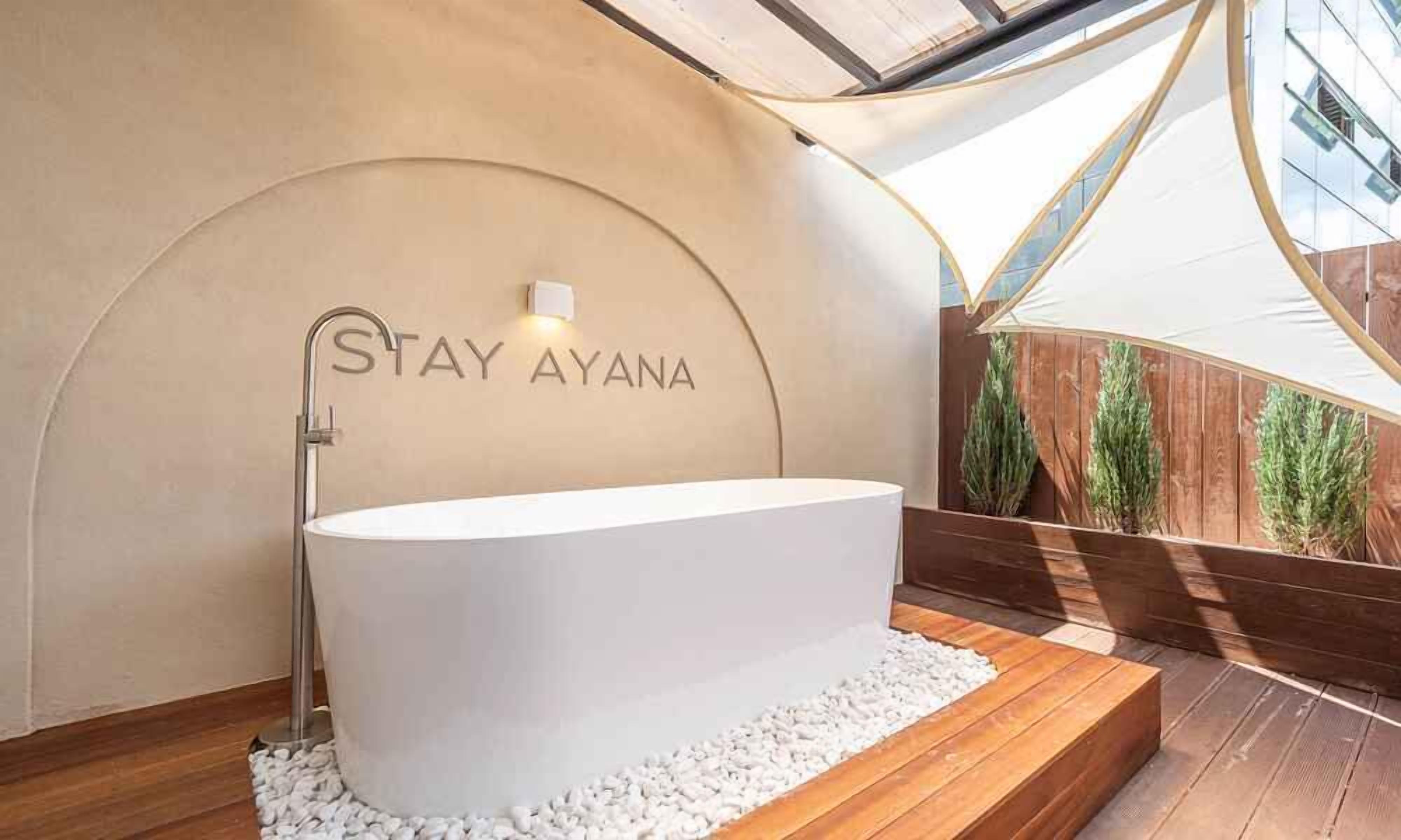 Un bagno moderno con una vasca freestanding, un porta asciugamani e un punto luce a parete.