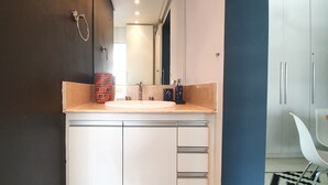 A modern bathroom with a white sink, a mirror, and a towel rack. - Moderno e Vibrante na Augusta (São Paulo)