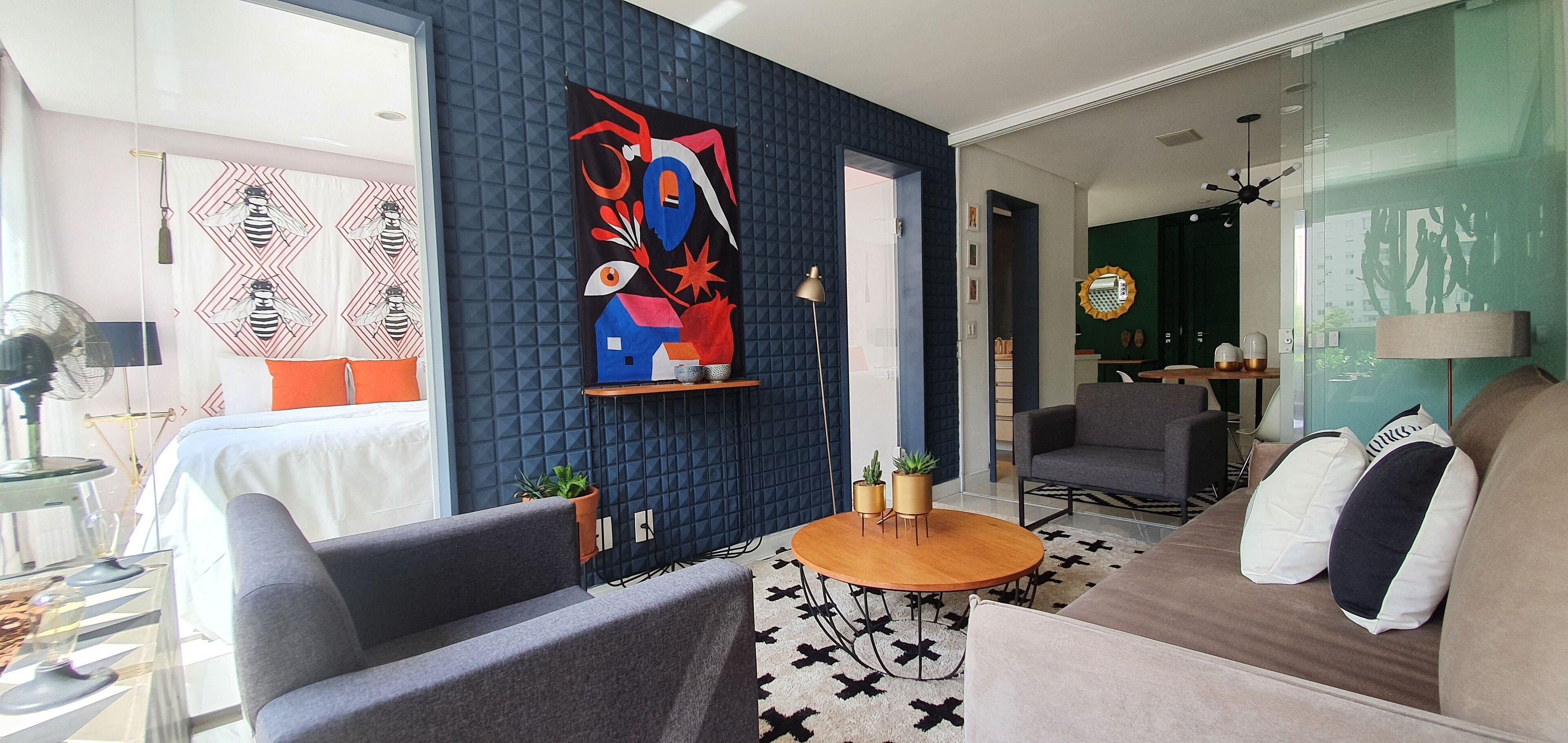 Un salon moderne avec un canapé, des fauteuils, une table basse et un tableau accroché au mur.