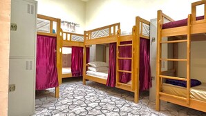 A dormitory room with bunk beds, a patterned floor, and a white cabinet. - Hello Hostel (Dubai)