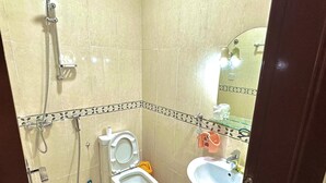 A bathroom with a toilet, sink, and shower. - Hello Hostel (Dubai)
