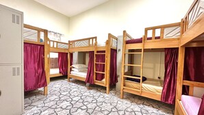 A dormitory room with four bunk beds, a patterned floor, and a white wardrobe. - Hello Hostel (Dubai)