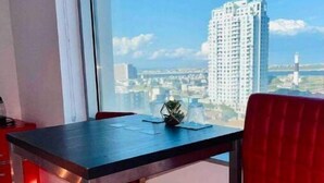 Une chambre moderne avec une grande fenêtre, une table et une chaise rouge.