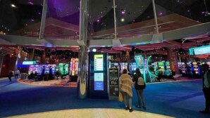 Un vaste espace intérieur doté d’un pilier central, entouré de jeux d’arcade et de coins salon.