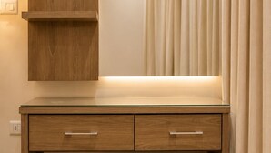 Un bureau en bois avec un miroir, deux tiroirs et un banc.