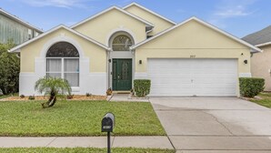 A two-story house with a garage, a mailbox, and a well-maintained lawn. - NEW*4 Bdrm, 3 Bath* Updated Detached Pool Home, 10 Minutes to Disney (Kissimmee)