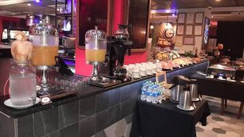 A buffet setup with various food and drink dispensers, including a coffee machine and a beverage dispenser.