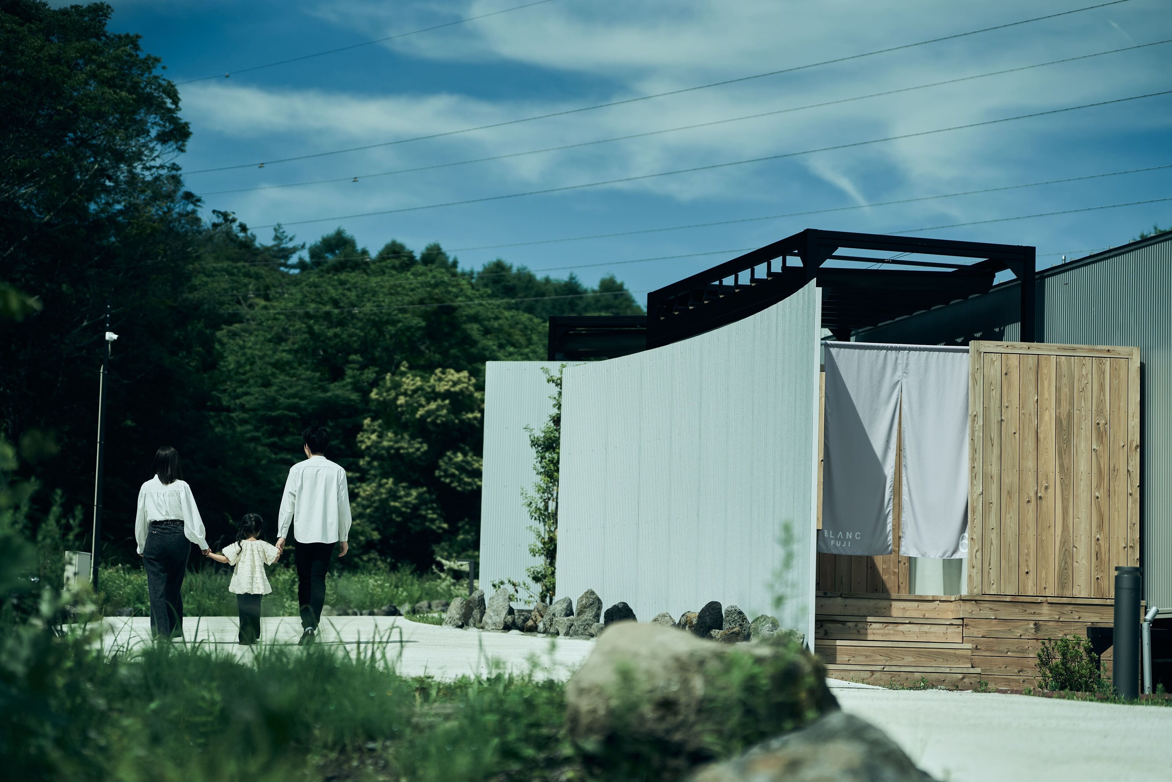 A modern building with a wooden deck and a white curtain.