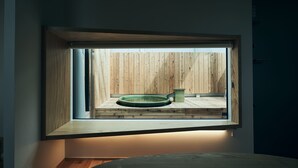 A room with a window overlooking a wooden deck and a circular hot tub. - BLANC FUJI (Fujiyoshida)