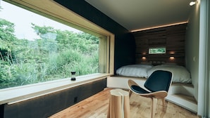 A bedroom with a large window, a bed, a chair, and a small table. - BLANC FUJI (Fujiyoshida)