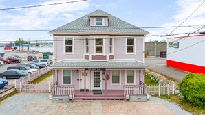 A two-story building with a front porch, a garage, and a driveway. - The Nightingale Nest (Stanwood)