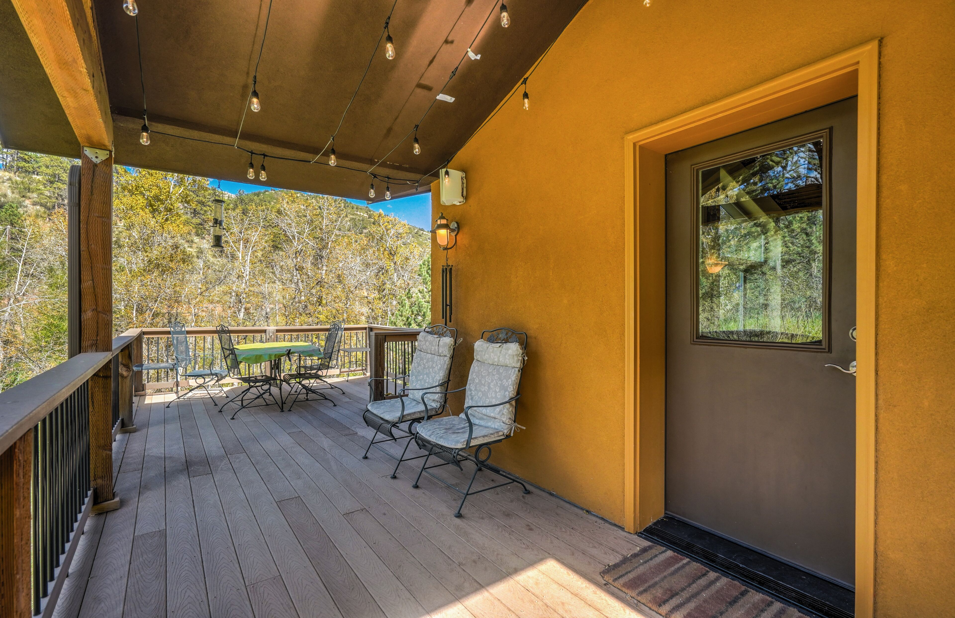 A wooden deck with outdoor seating and a door to a building.