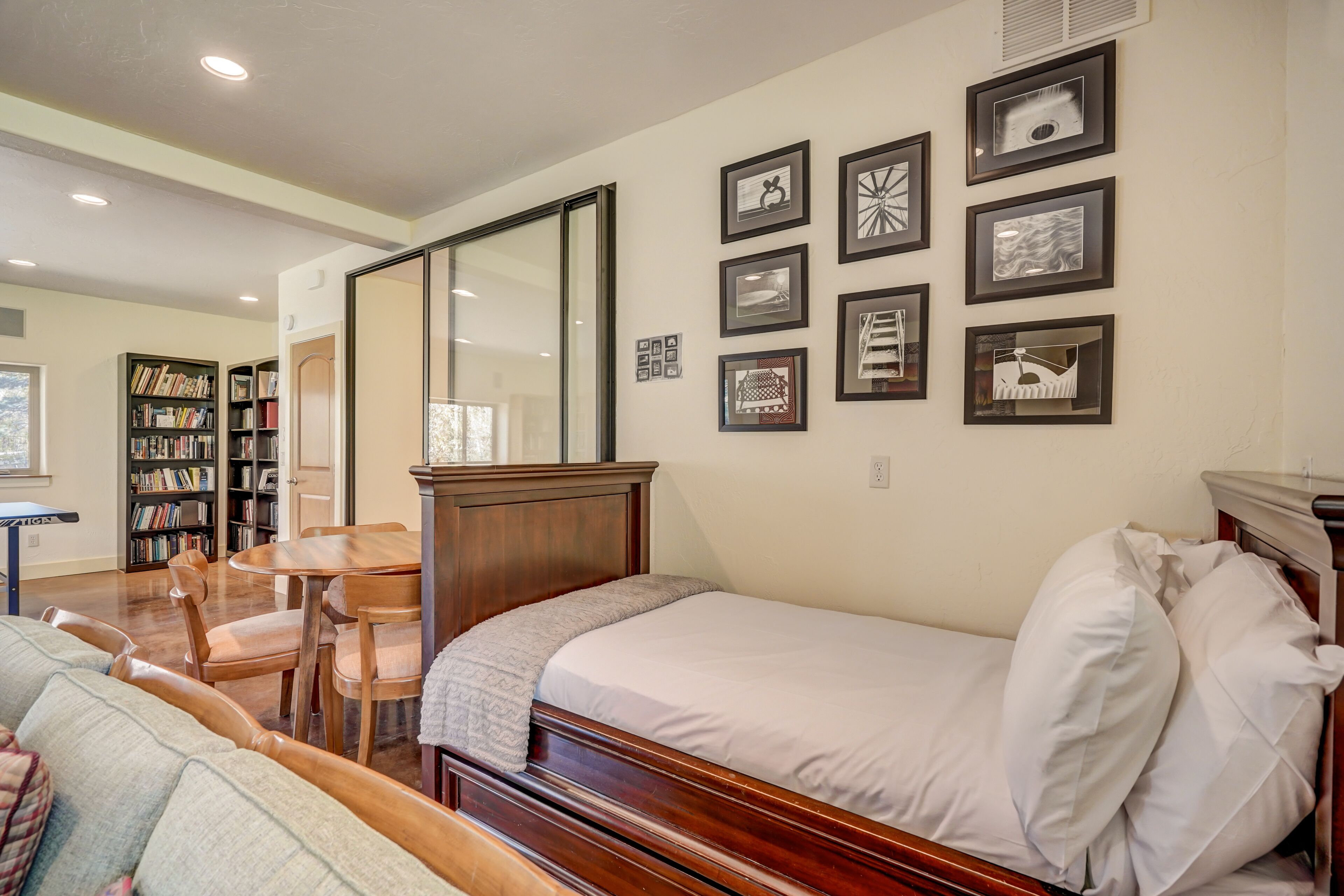 Un dormitorio con una cama de madera, un escritorio y una estantería.