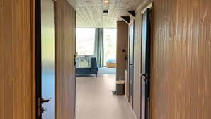 Un pasillo con puertas de madera que dan a una habitación con cama y ventana.