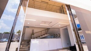 A modern building with a glass entrance, a staircase, and a reception desk. - Imperial Boni Hotels and Resorts (Akure)
