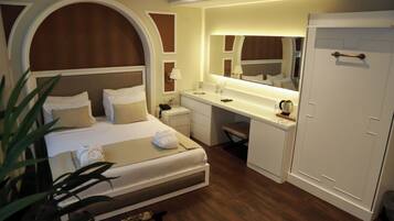 A hotel room with a bed, desk, and wardrobe.