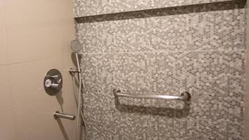 Een douche met een handdouche en een greep.