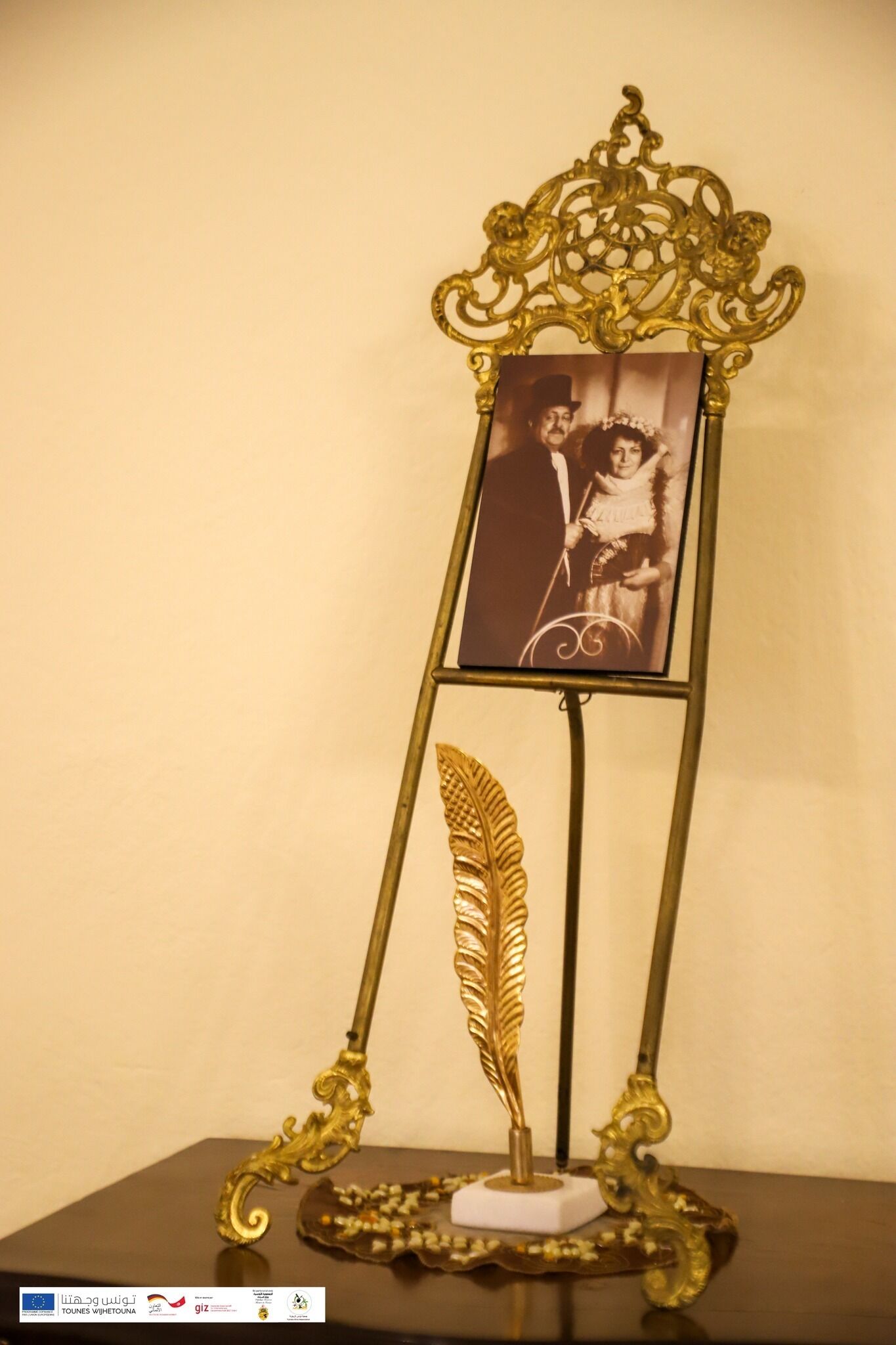 Moldura decorativa com uma pena e uma fotografia antiga.
