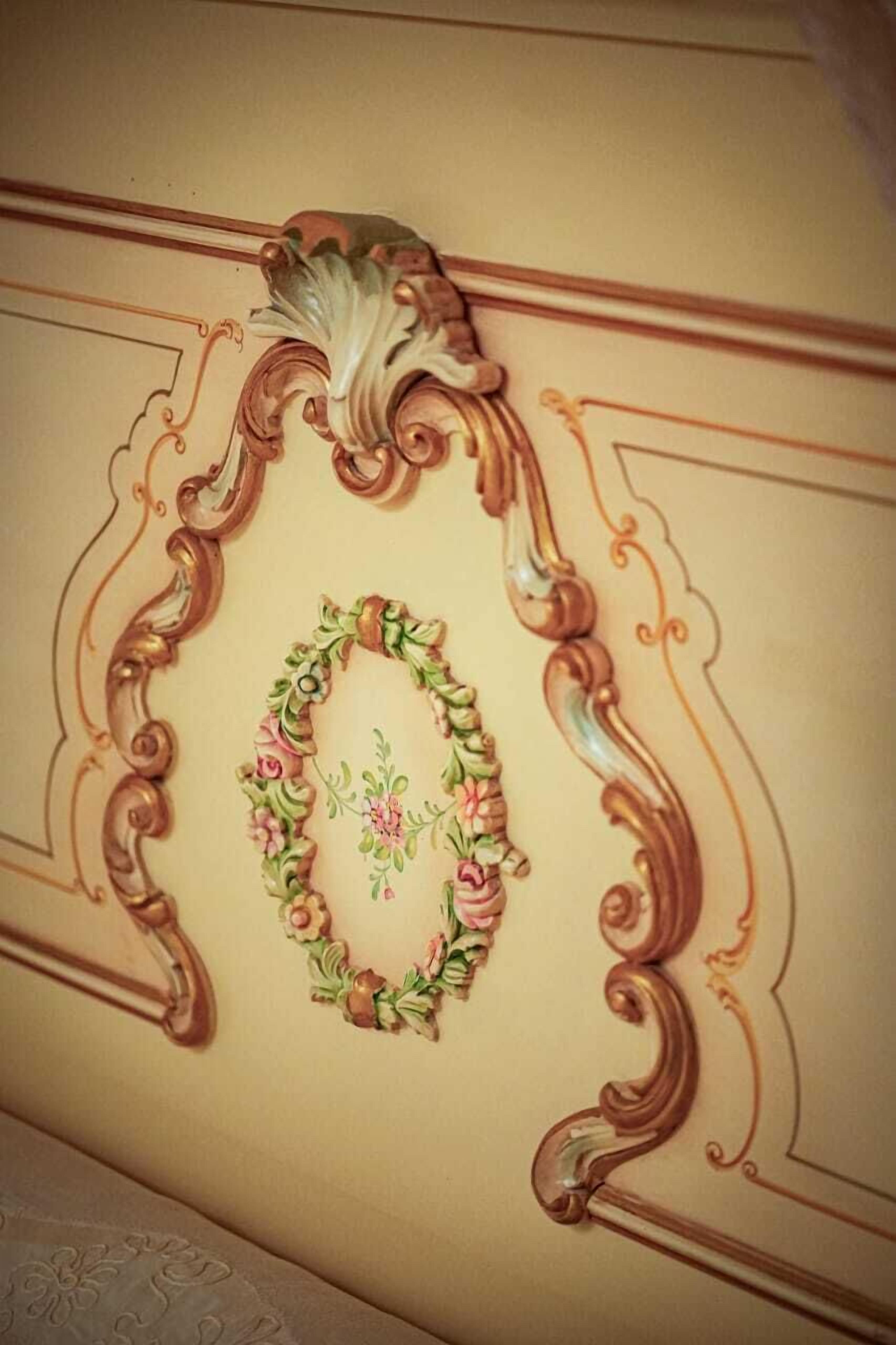 Un techo decorativo con molduras ornamentales y un diseño floral.