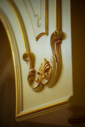 A detailed architectural feature with ornate gold and white decorations, likely part of a building's interior design.