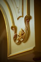 Un detalle arquitectónico con ornamentales decoraciones doradas y blancas, probablemente parte del diseño interior de un edificio.