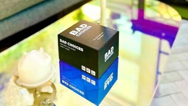 A BAD CHOICES box on a glass table with a candle and a decorative item. - Accept daily stays NYC West Village Entire Place (New York)