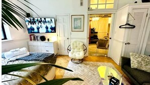 A hotel room with a bed, a chair, a TV, a desk, and a wardrobe. - Accept daily stays NYC West Village Entire Place (New York)