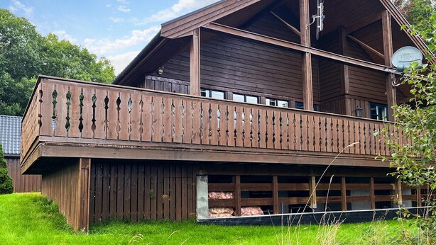 A two-story wooden building with a balcony, large windows, and a satellite dish. - Amazing home in Midsund with WiFi (Midsund)