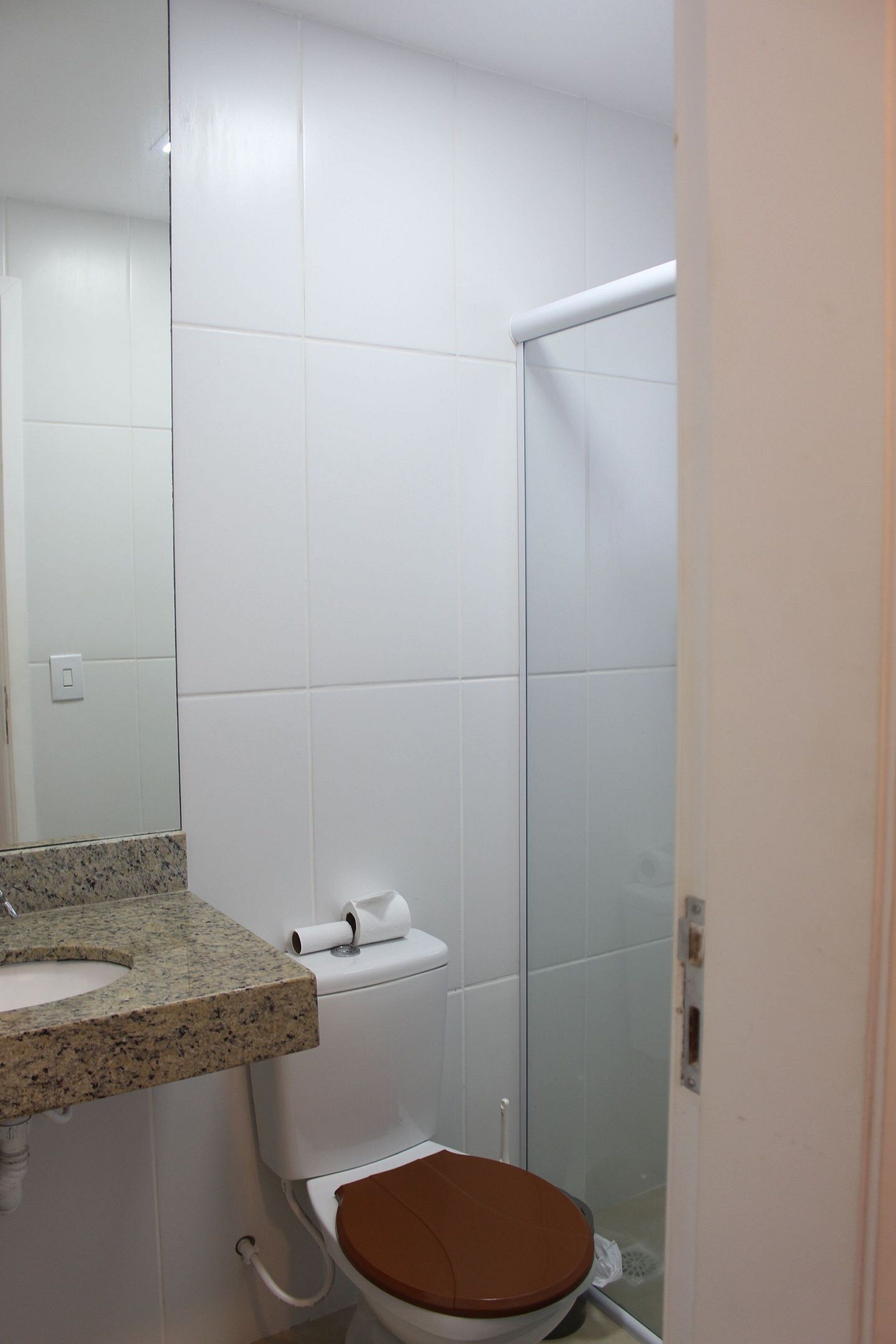 A bathroom with a toilet, sink, and shower.