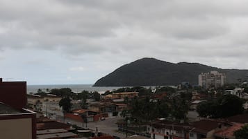 Eine Küstenstadt mit einem markanten Hügel im Hintergrund, einer Mischung aus Wohnhäusern und Blick auf das Meer.