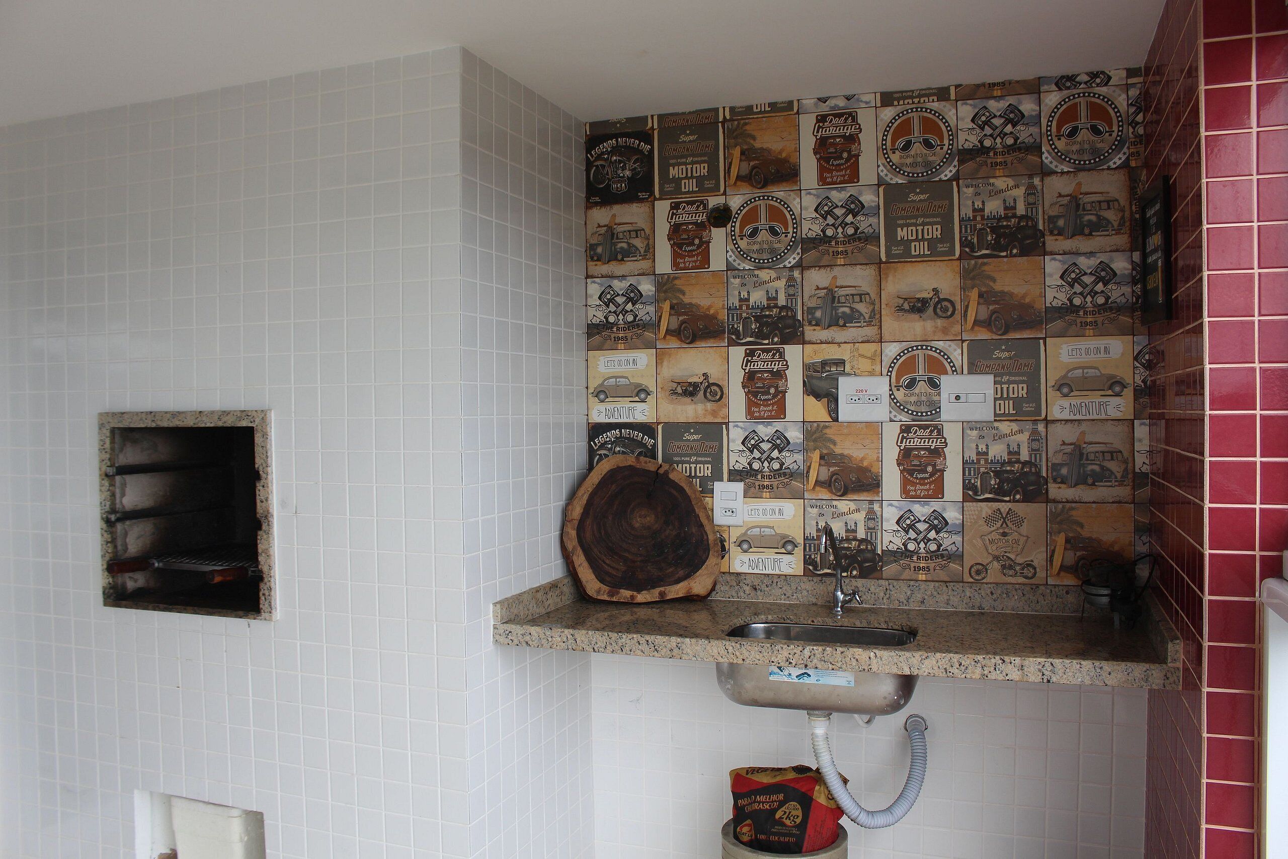 Una cucina con zoccolo di piastrelle caratterizzato da decorazioni a tema automobilistico vintage e avventura.