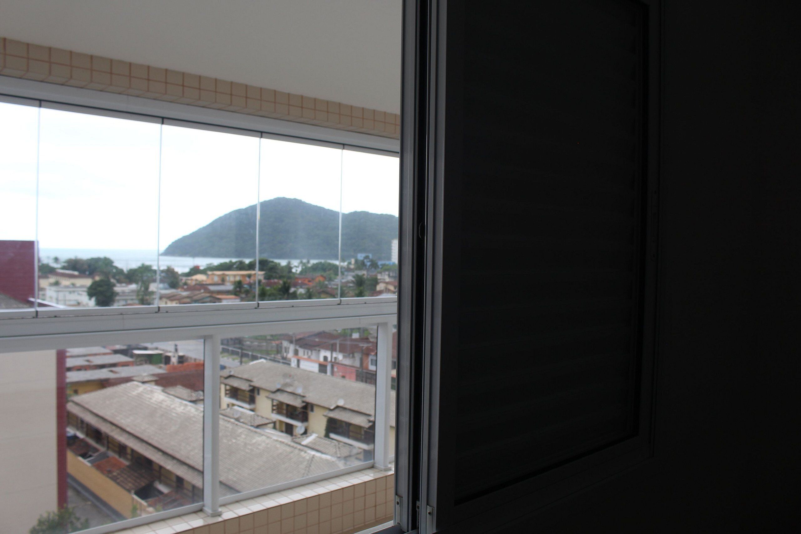 A view through a window with a view of buildings and a mountain.