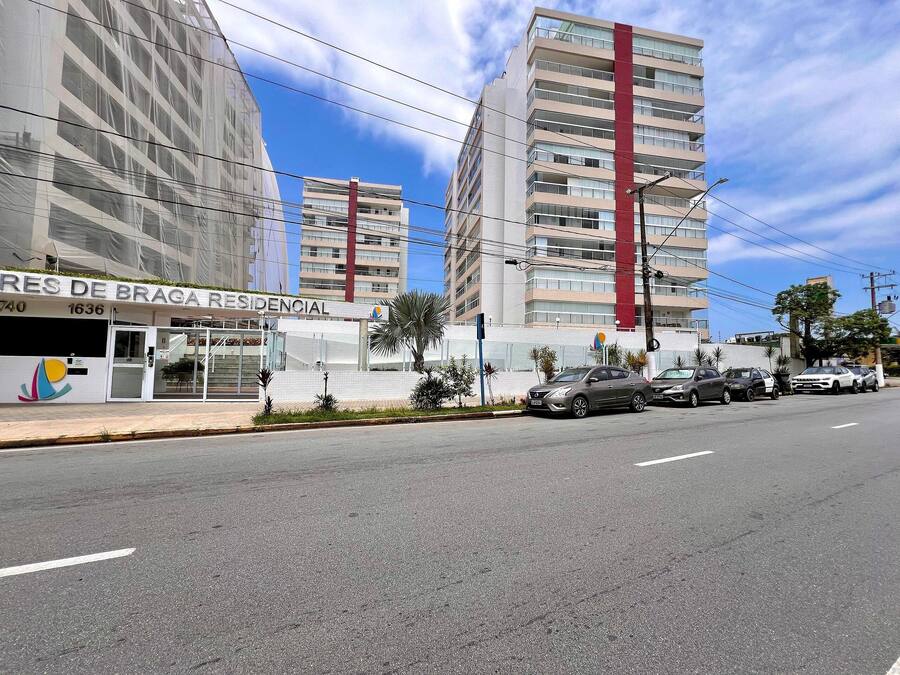 Un hôtel moderne qui se distingue par un élément vertical rouge bien visible, de nombreux étages et un ciel dégagé.