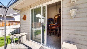 A patio with a table and chairs, a sliding glass door leading to an interior dining area, and a decorative wall piece. - 6 Mi to Dtwn Yakima: Central Washington Home (Yakima)