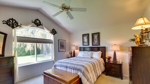 A bedroom with a large window, a ceiling fan, a bed with a patterned bedspread, a nightstand with a lamp, and a dresser. - 6 Mi to Dtwn Yakima: Central Washington Home (Yakima)