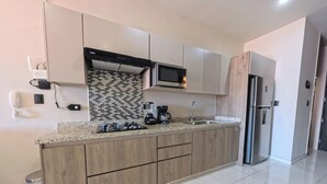Una cocina moderna con encimera de granito, electrodomésticos de acero inoxidable y muebles de madera.