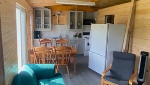 A cozy cabin interior with a dining area, kitchen, and seating space.