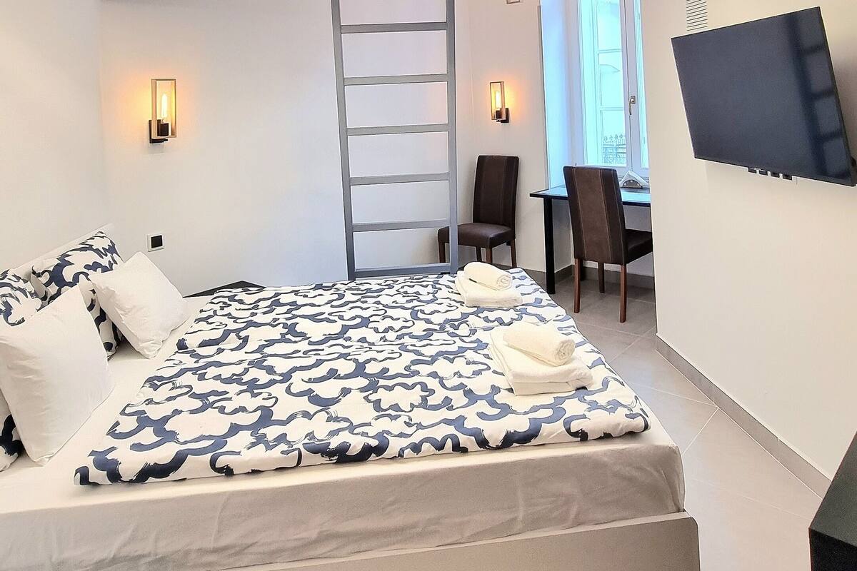 Un dormitorio moderno con una cama grande, un escritorio y una escalera.