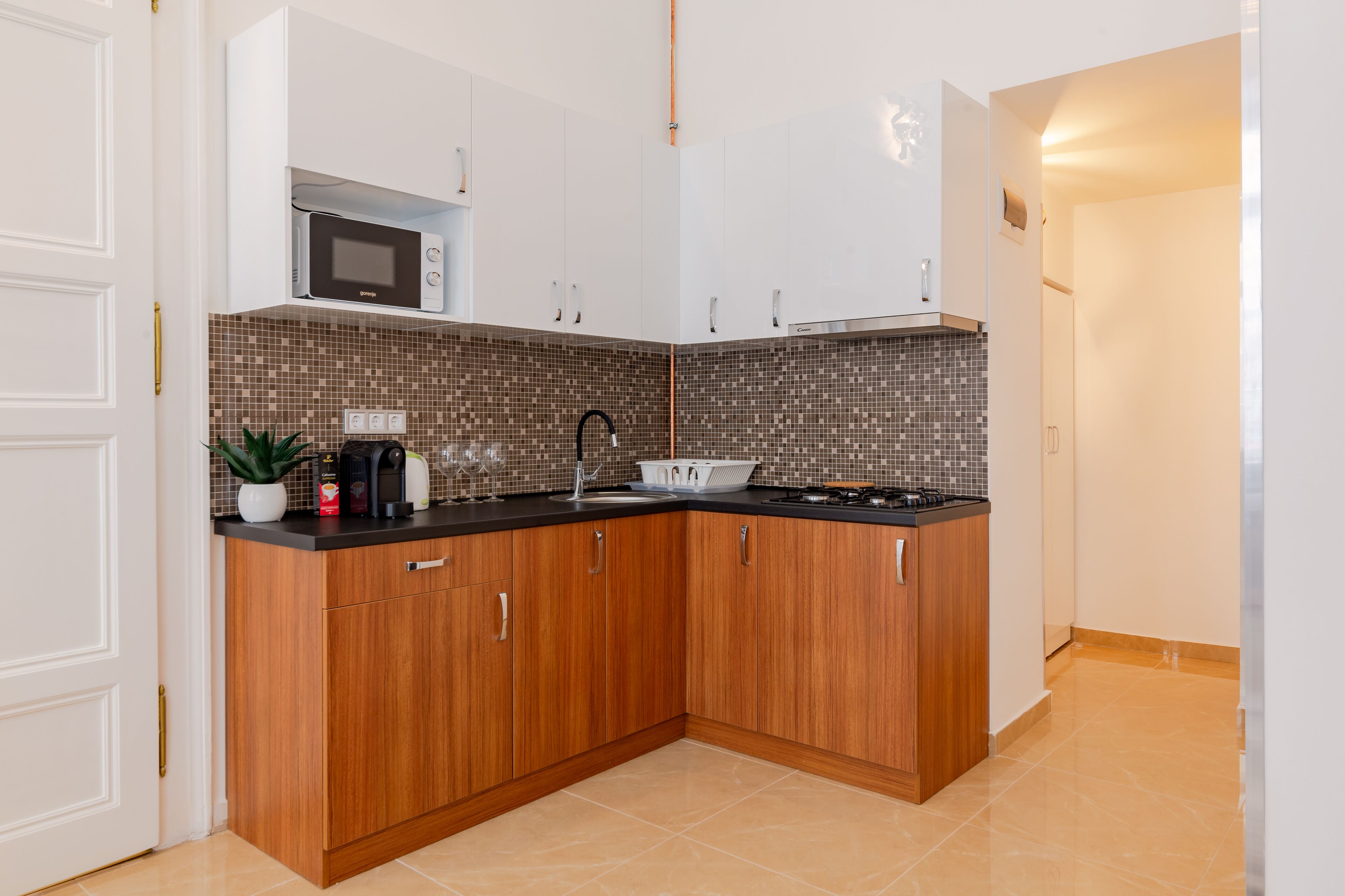 Una cocina moderna con armarios de madera, microondas y salpicadero de azulejos.