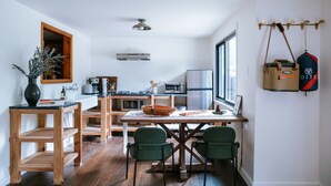A modern kitchen with wooden furniture, a dining table, and chairs. - The Leeway - Two-Bedroom Suite (Mt Tremper)