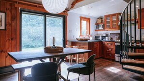 A spacious kitchen with wooden cabinets, a large island, and a dining area with chairs.