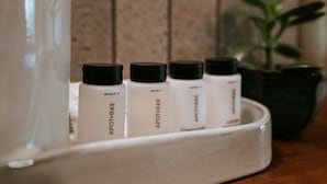 Ein Tablett mit vier Flaschen, beschriftet mit 'APOTHEKE' und 'CONDITIONER', auf einer Holzoberfläche.