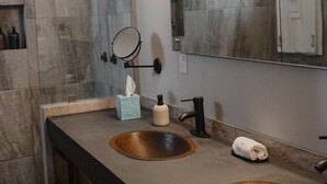 A modern bathroom with two sinks, a large mirror, and a vanity with a towel rack. - ROOM 7- Romantic 1 Bedroom Ocean Front Condo (El Rebase)