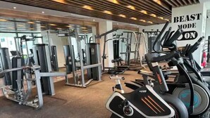 Un gimnasio con diversas máquinas de ejercicio, incluyendo una bicicleta estática y máquinas de pesas.